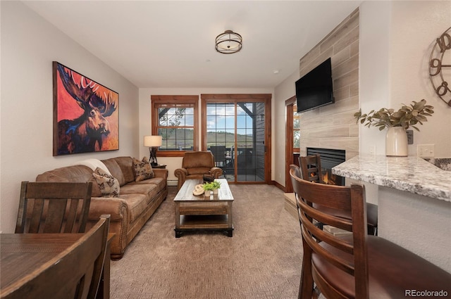 living room featuring a tile fireplace and light colored carpet