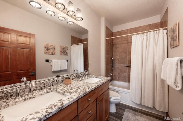 full bathroom featuring a textured ceiling, toilet, vanity, shower / tub combo with curtain, and hardwood / wood-style flooring