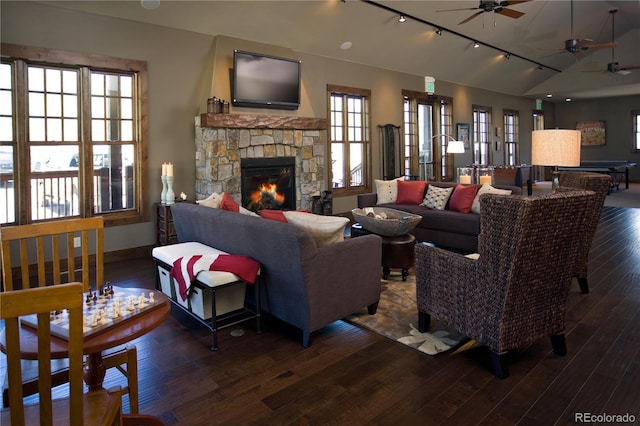 living room with lofted ceiling, track lighting, ceiling fan, dark wood-type flooring, and a fireplace