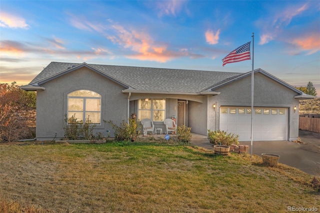 single story home featuring a garage and a lawn