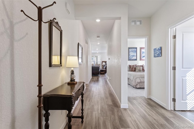 hall with baseboards, visible vents, wood finished floors, and recessed lighting