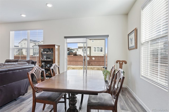 dining area featuring light wood-style floors, plenty of natural light, and baseboards