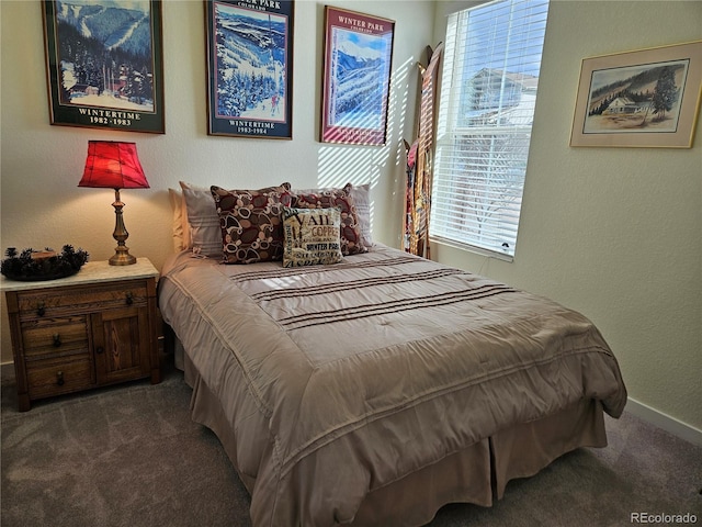 bedroom featuring carpet flooring, a textured wall, and baseboards