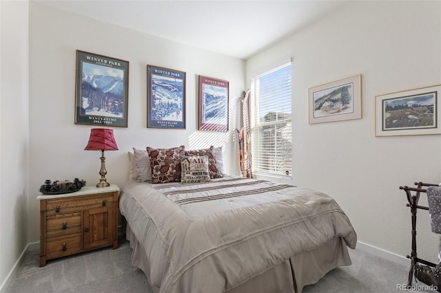 bedroom featuring light carpet and baseboards