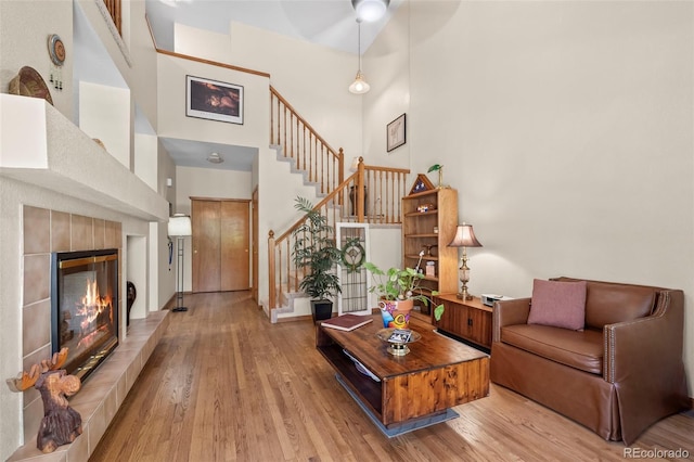 9869 Julian Way # B, Westminster, CO 80031 - living area featuring a high ceiling, stairway, wood finished floors, and a tiled fireplace