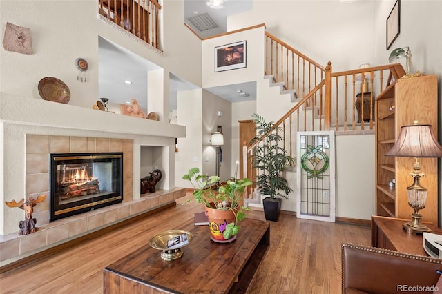 9869 Julian Way # B, Westminster, CO 80031 - living area featuring a towering ceiling, wood finished floors, stairway, and a tile fireplace