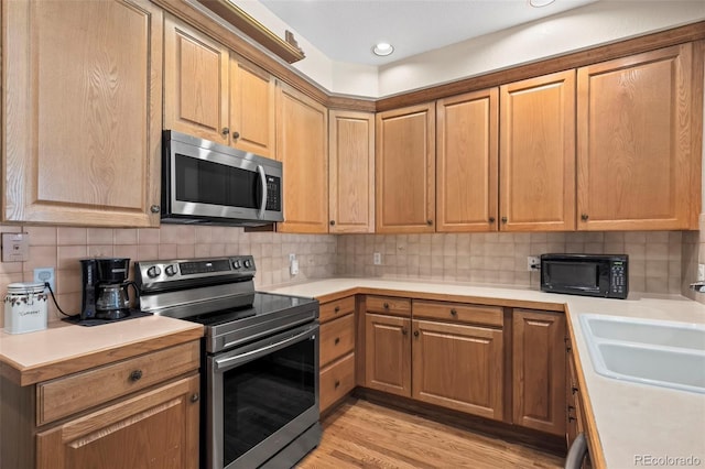 9869 Julian Way # B, Westminster, CO 80031 - kitchen with stainless steel appliances, light countertops, backsplash, light wood-style flooring, and recessed lighting