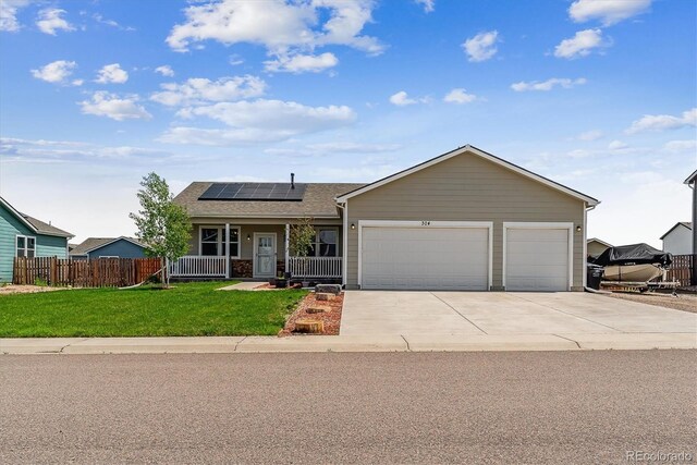 304 S 2nd Ave, Deer Trail, CO 80105 - ranch-style home with roof mounted solar panels, a garage, concrete driveway, a porch, and roof with shingles
