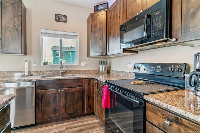 304 S 2nd Ave, Deer Trail, CO 80105 - kitchen with black appliances, a sink, light wood-style flooring, and light stone counters