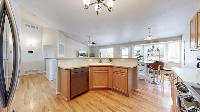 11560 River Run Cir, Commerce City, CO 80640 - kitchen with appliances with stainless steel finishes, a sink, light wood-style flooring, light countertops, and a chandelier