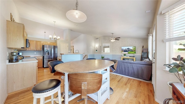 11560 River Run Cir, Commerce City, CO 80640 - kitchen with stainless steel fridge, lofted ceiling, light brown cabinets, light wood-style floors, and ceiling fan