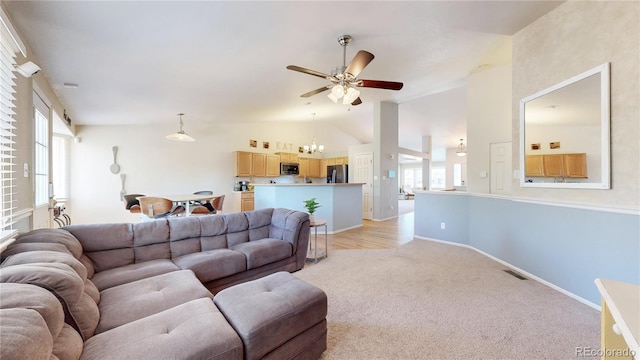11560 River Run Cir, Commerce City, CO 80640 - living room featuring a chandelier, ceiling fan, light carpet, lofted ceiling, and baseboards