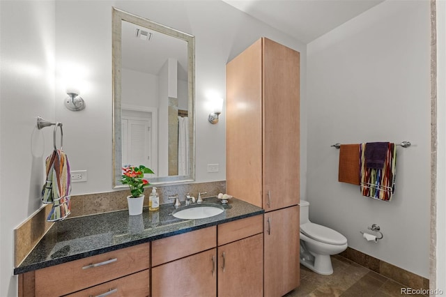 bathroom featuring tile patterned flooring, vanity, and toilet