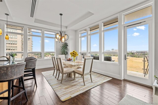 sunroom with a notable chandelier and a raised ceiling