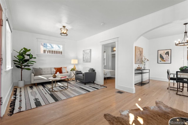 living room with light wood-type flooring and a notable chandelier