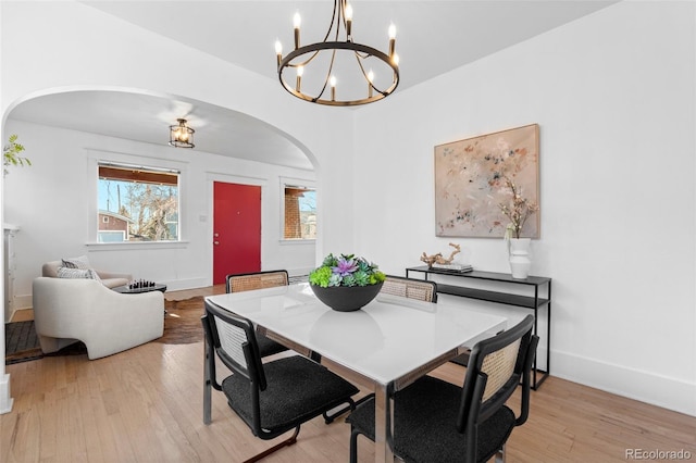 dining area with light hardwood / wood-style floors and a chandelier