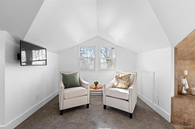 living area featuring vaulted ceiling and dark colored carpet