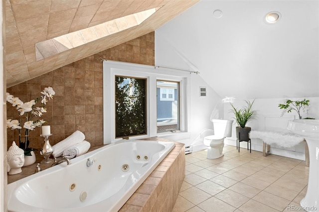 bathroom with toilet, tiled bath, vaulted ceiling with skylight, tile patterned flooring, and a baseboard heating unit