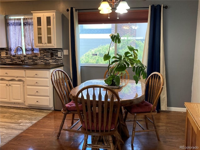 dining room featuring wood finished floors, baseboards, and a chandelier