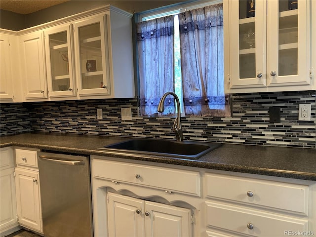 kitchen featuring dishwasher, a sink, dark countertops, and backsplash