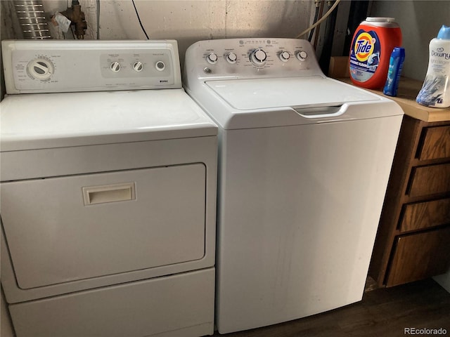 laundry area featuring washer and dryer and dark wood-type flooring