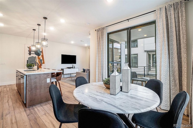 dining space featuring sink and light hardwood / wood-style flooring