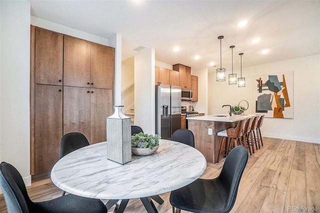 dining room with sink and light wood-type flooring