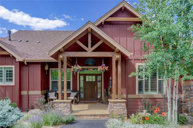 31189 Manitoba Dr, Evergreen, CO 80439 - doorway to property featuring board and batten siding, roof with shingles, and covered porch