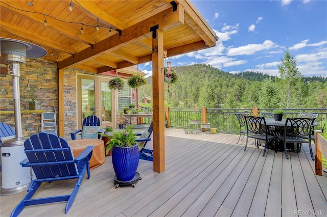 31189 Manitoba Dr, Evergreen, CO 80439 - deck with outdoor dining space, a view of trees, and french doors
