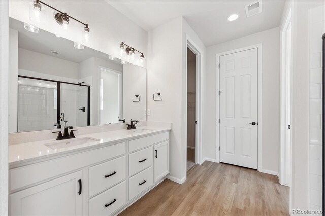 1300 Sienna Peak Cir, Erie, CO 80516 - full bathroom with a sink, visible vents, a shower stall, and wood finished floors