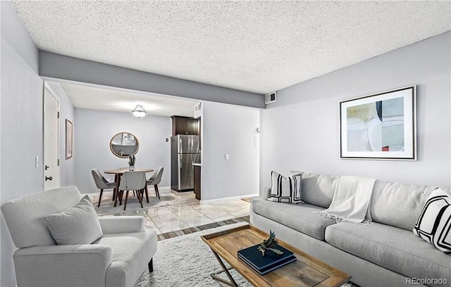 living room featuring a textured ceiling and light marble finish floors