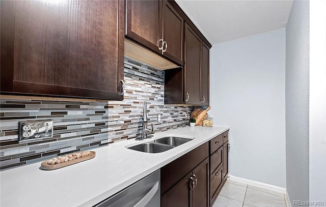 kitchen with a sink, decorative backsplash, dark brown cabinetry, light countertops, and light tile patterned flooring