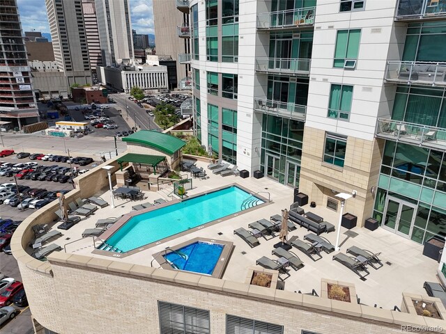 community pool with a patio area and a city view