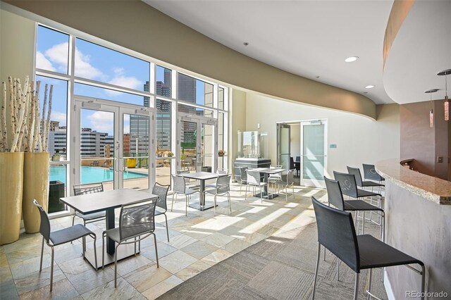 view of patio with a community pool, outdoor dining area, and a city view