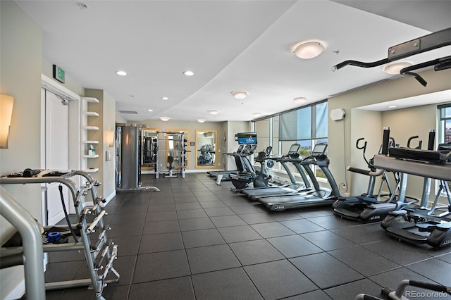 exercise room featuring baseboards, a wall of windows, plenty of natural light, and recessed lighting