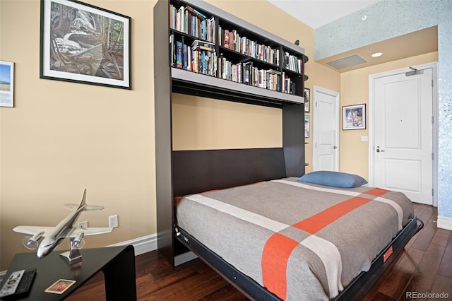 bedroom with dark wood-style flooring and baseboards