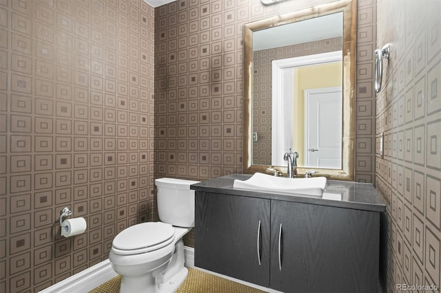2001 Lincoln St Unit 2420, Denver, CO 80202 - bathroom featuring toilet, wallpapered walls, and vanity