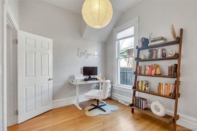 office area featuring vaulted ceiling, light wood-style flooring, and baseboards