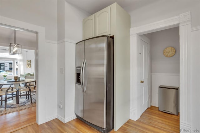 kitchen with stainless steel refrigerator with ice dispenser and light wood-style floors