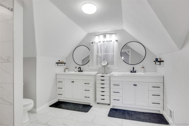 bathroom with lofted ceiling, marble finish floor, two vanities, and a sink