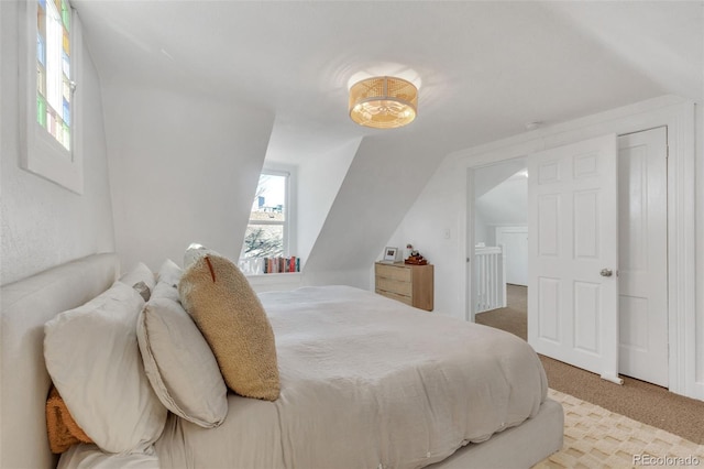 bedroom featuring vaulted ceiling and carpet flooring