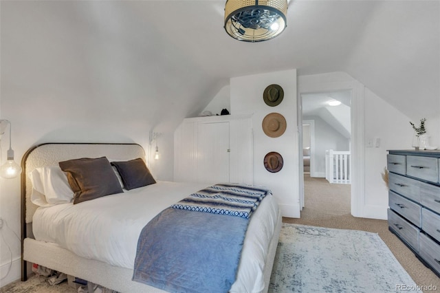 carpeted bedroom featuring lofted ceiling and baseboards