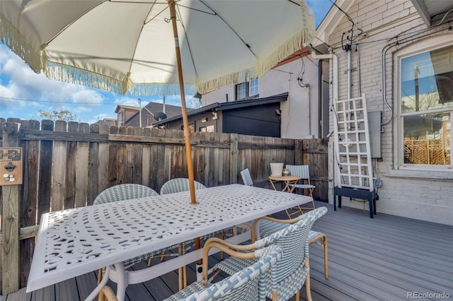 wooden deck with outdoor dining space and fence