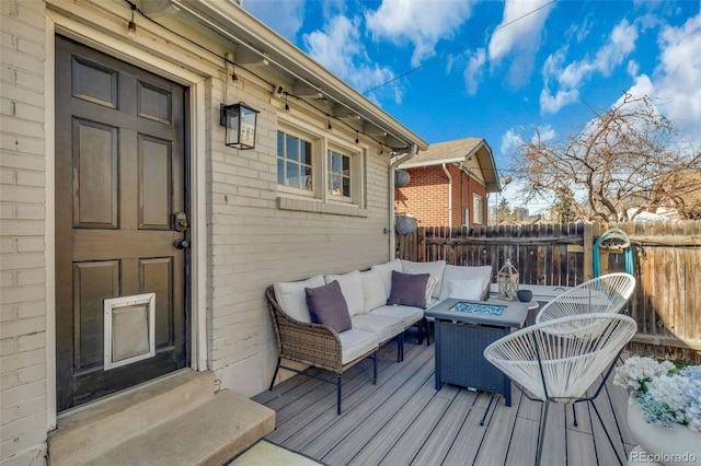 wooden deck with an outdoor living space with a fire pit and fence