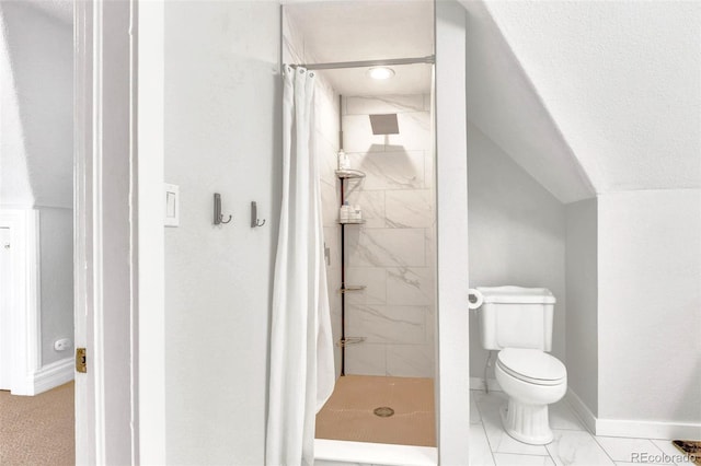 full bath with vaulted ceiling, a shower stall, toilet, and baseboards