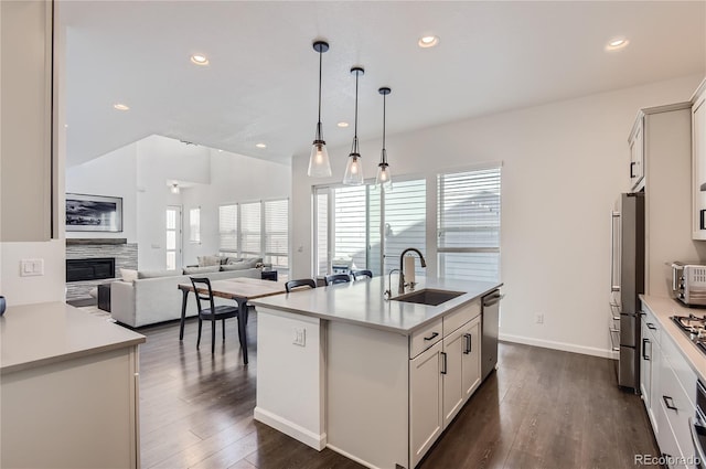 kitchen with pendant lighting, white cabinetry, a kitchen island with sink, and sink