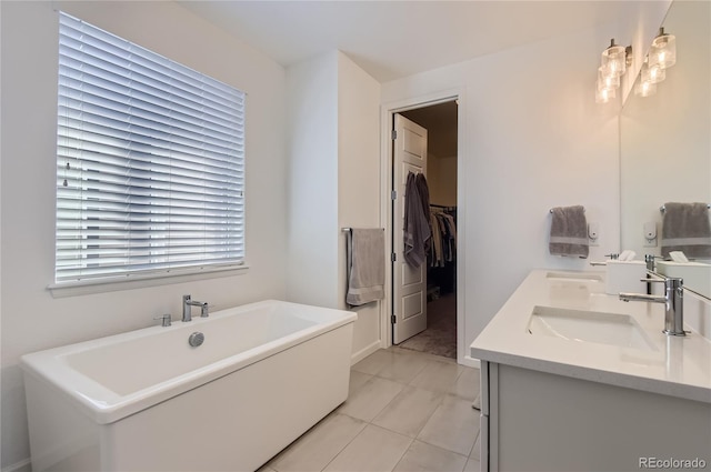 bathroom with tile patterned floors, a bath, and vanity