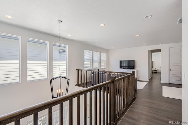 hallway featuring a textured ceiling and dark hardwood / wood-style flooring