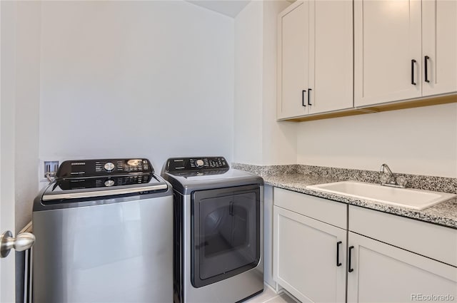 washroom featuring cabinets, separate washer and dryer, and sink