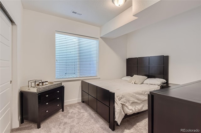 bedroom with light colored carpet and a closet